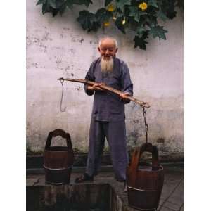  China, Anhui Province, Old Man Fetching Water with Buckets 
