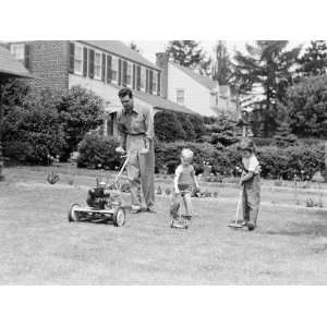  Father Cutting Lawn With Power Mower, Two Boys Using Toy Rake 
